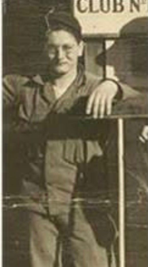 Man in uniform leaning on a structure with