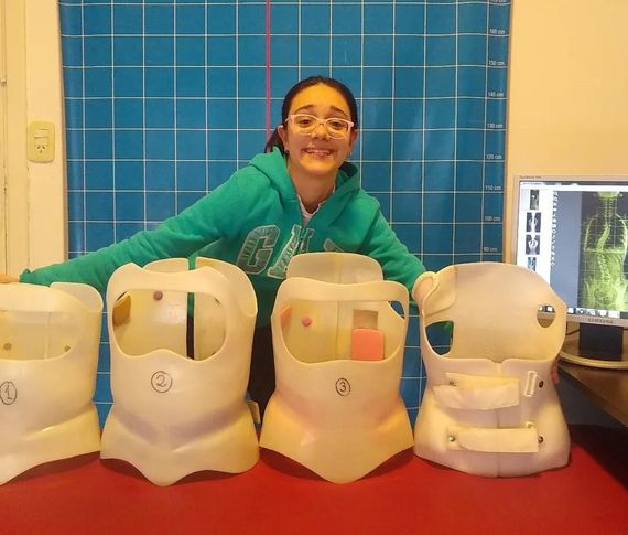 Dos mujeres sonriendo y abrazándose frente a un telón de fondo de oropel plateado en una fiesta.