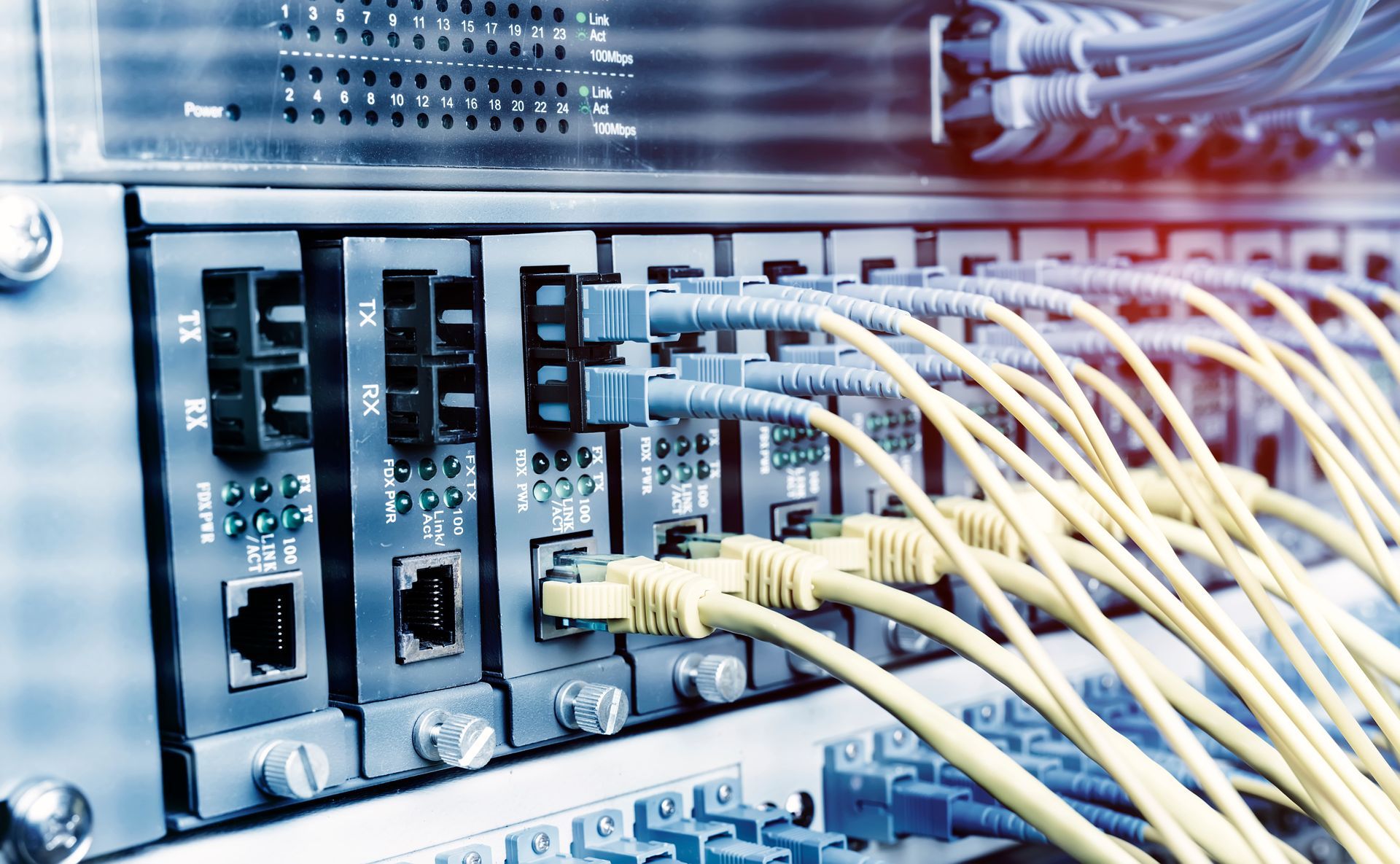 Close-up of network switches with multiple yellow Ethernet cables plugged in