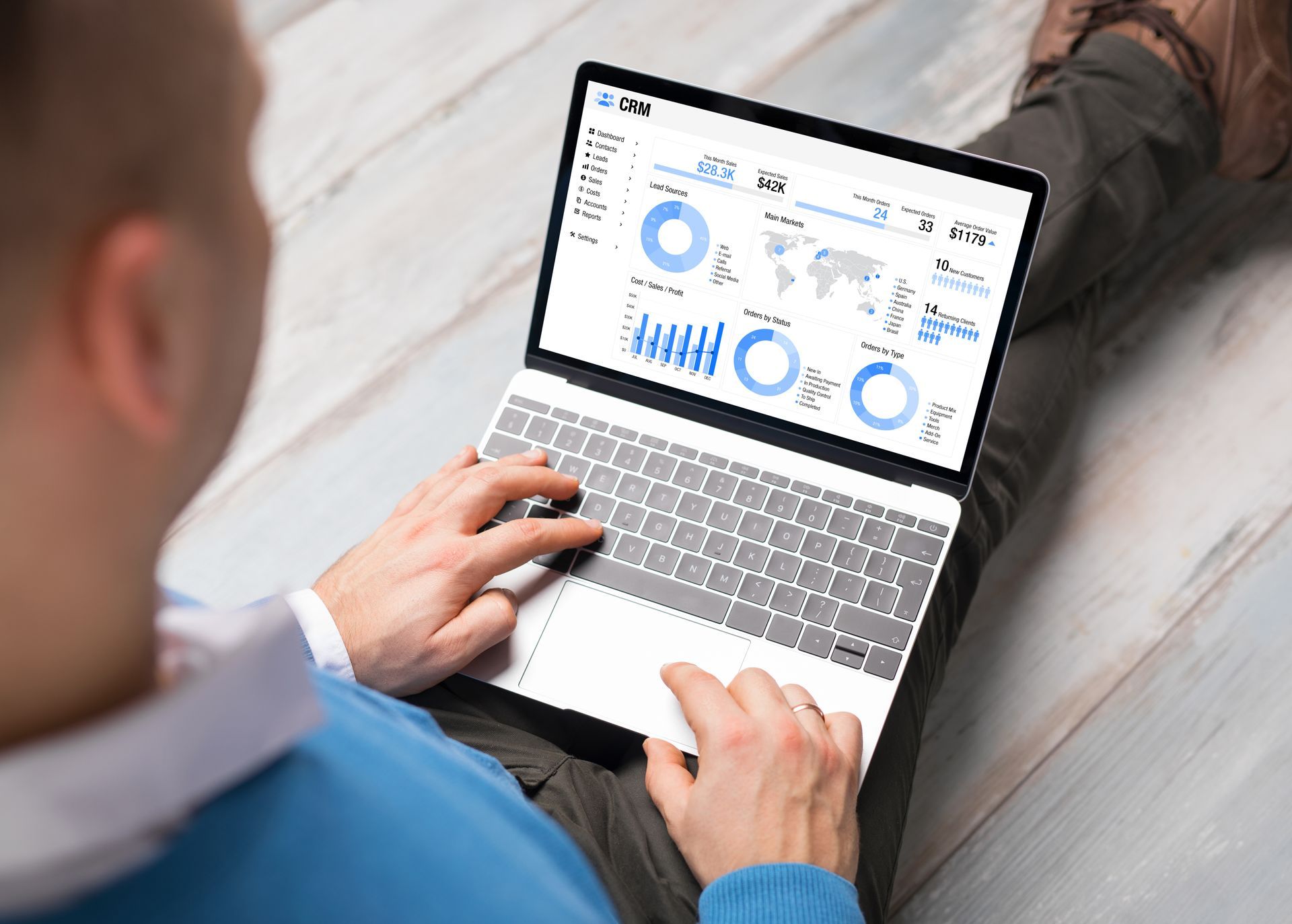 Person using a laptop with analytics dashboards on screen, viewed from above at a desk