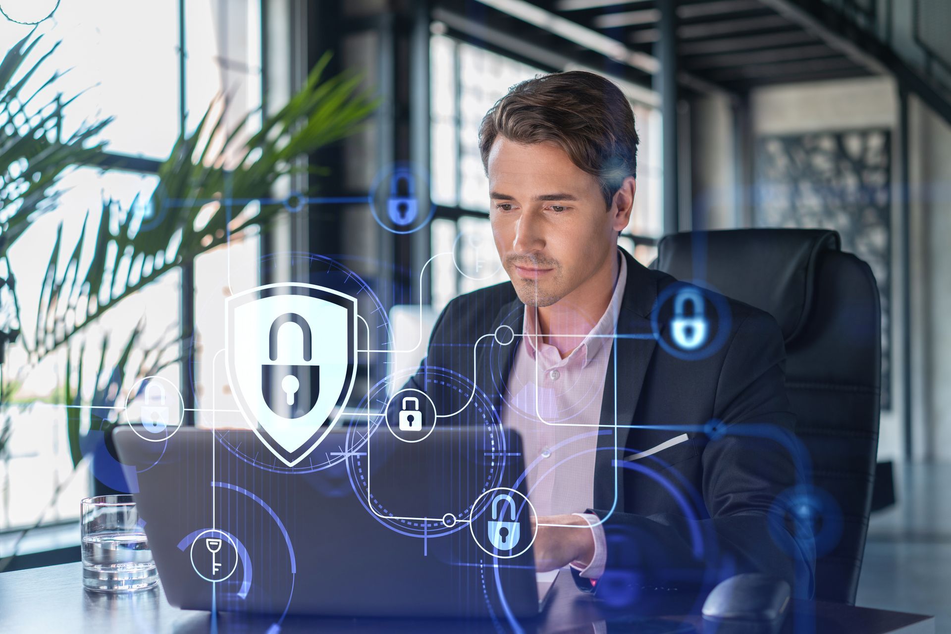 Man at a desk using a laptop, with digital security lock icons overlayed in a modern office.