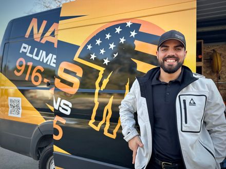 Smiling man beside a yellow-and-black van with “NA PHOENIX 916-” and a QR code on the side