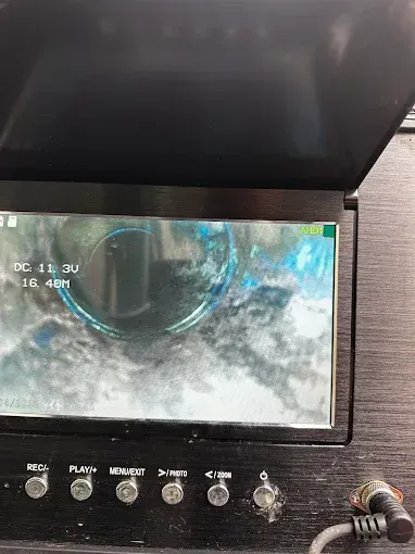 Small screen showing a blurry camera view, with control buttons below on a black device panel.