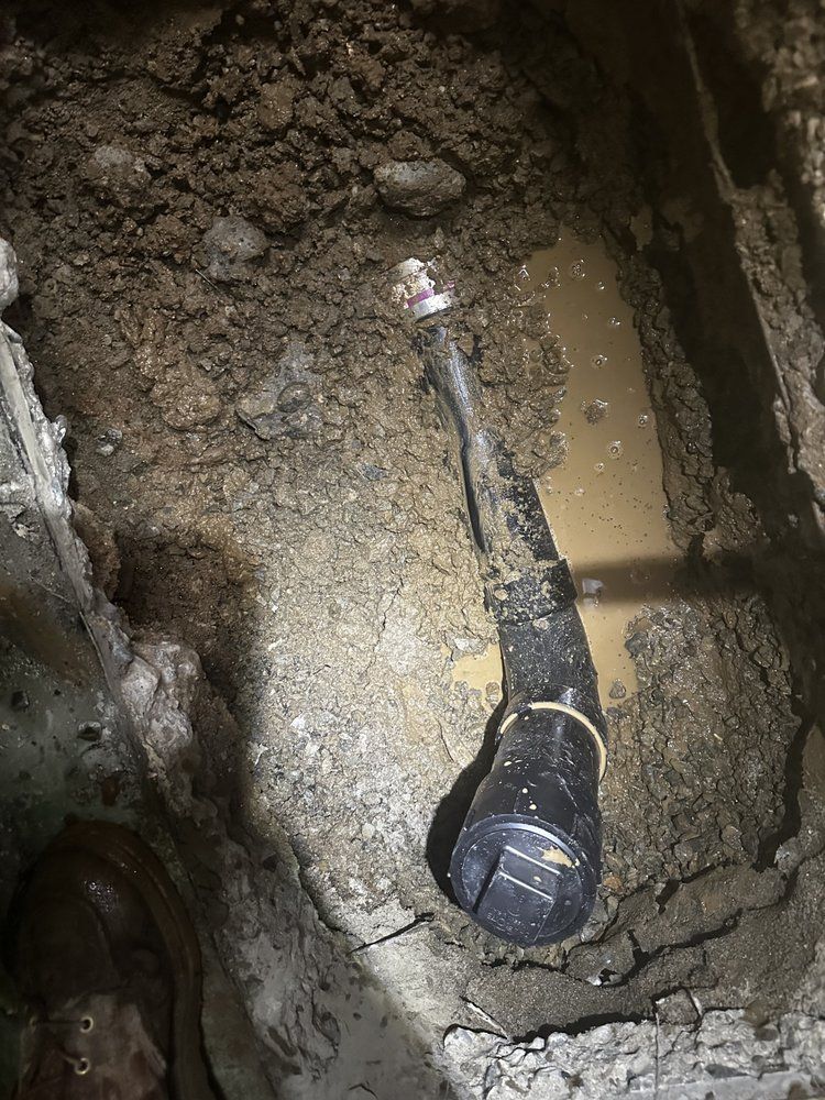 Dirty black microphone lying in a muddy trench with water and soil around it