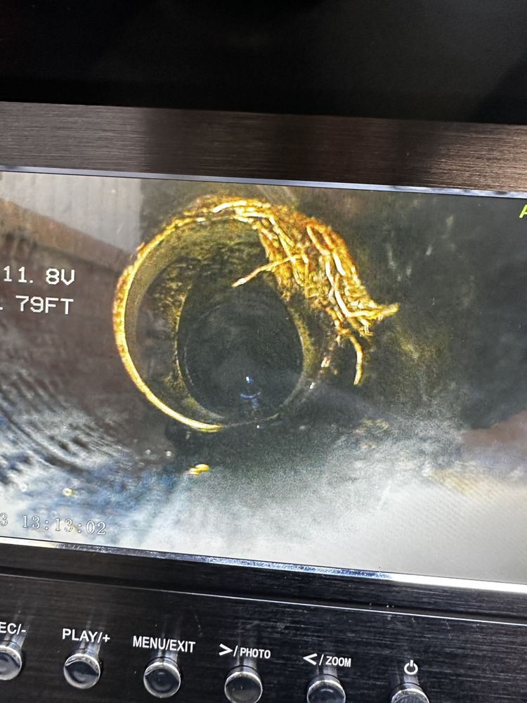 Close-up of a circular pipe or tunnel interior with yellowish buildup on a dark screen display