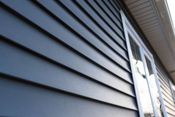 Blue siding on a house with a white-framed window.