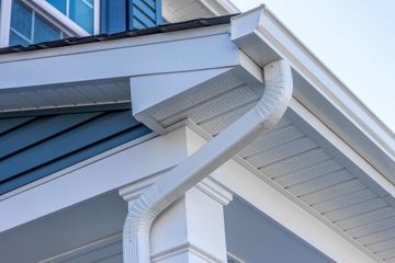 White gutters and trim on a blue and white house exterior.