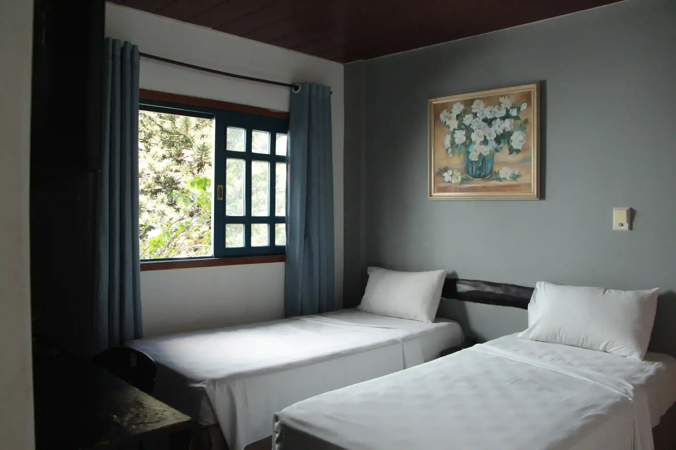 Um quarto com duas camas e uma pintura na parede CR HOTEL BUENO