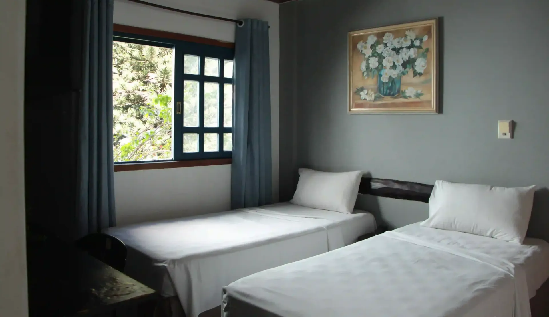 Um quarto com duas camas e uma pintura na paredeCR HOTEL BUENO