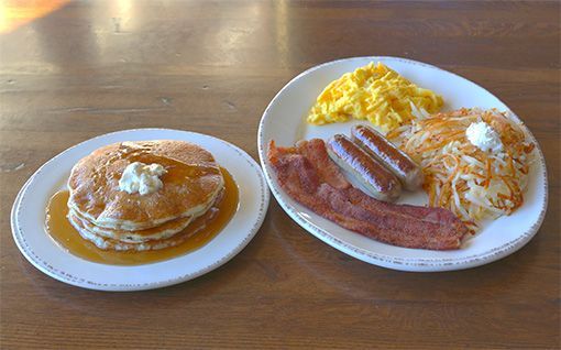Breakfast: Pancakes with syrup and butter; eggs, bacon, sausage, and hash browns.