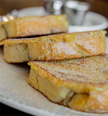 French toast slices dusted with powdered sugar on a plate.