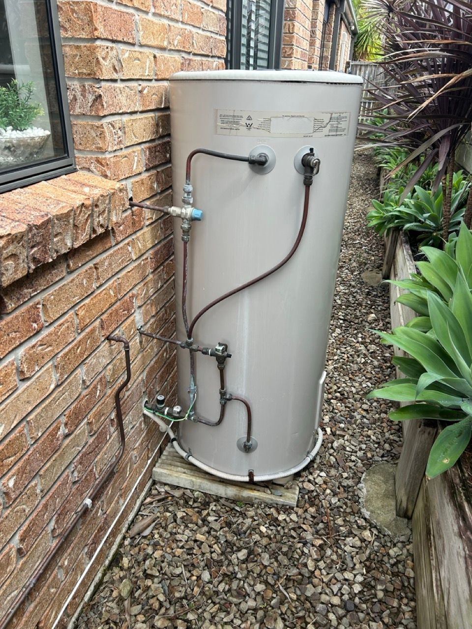 A Light-colored Outdoor Hot Water Cylinder Standing on a Concrete Pad — No.2 Plumbing In Kenmore, QLD