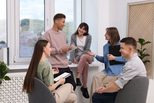Group of people in a bright room, conversing. Group of people in a bright room, conversing.