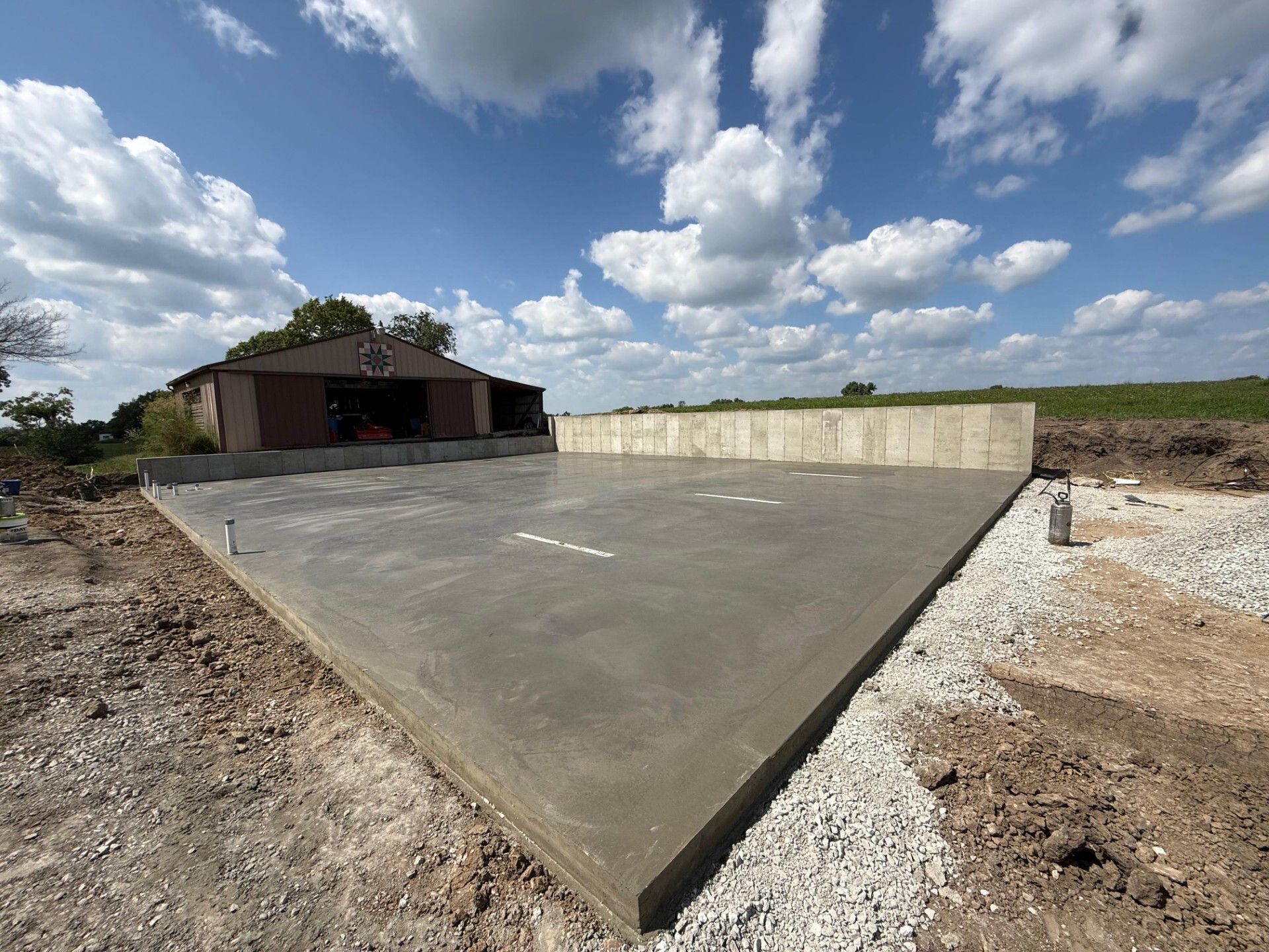 Concrete slab foundation at a construction site under a cloudy sky