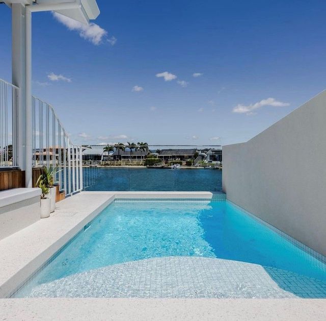 A large swimming pool with a view of a body of water