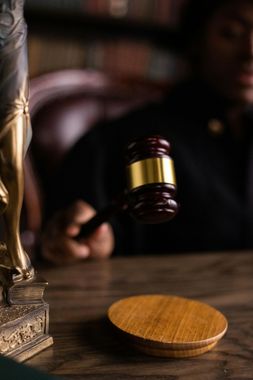 Judge’s gavel hovering above a wooden block on a courtroom bench