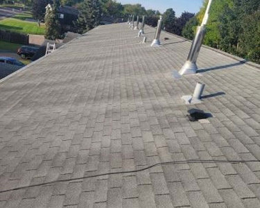A roof with a lot of shingles and a lot of skylights on it.