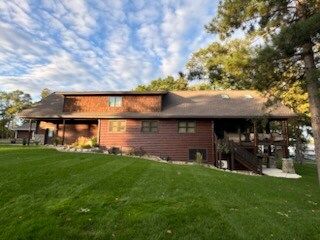 A large brick house with a lush green lawn in front of it.