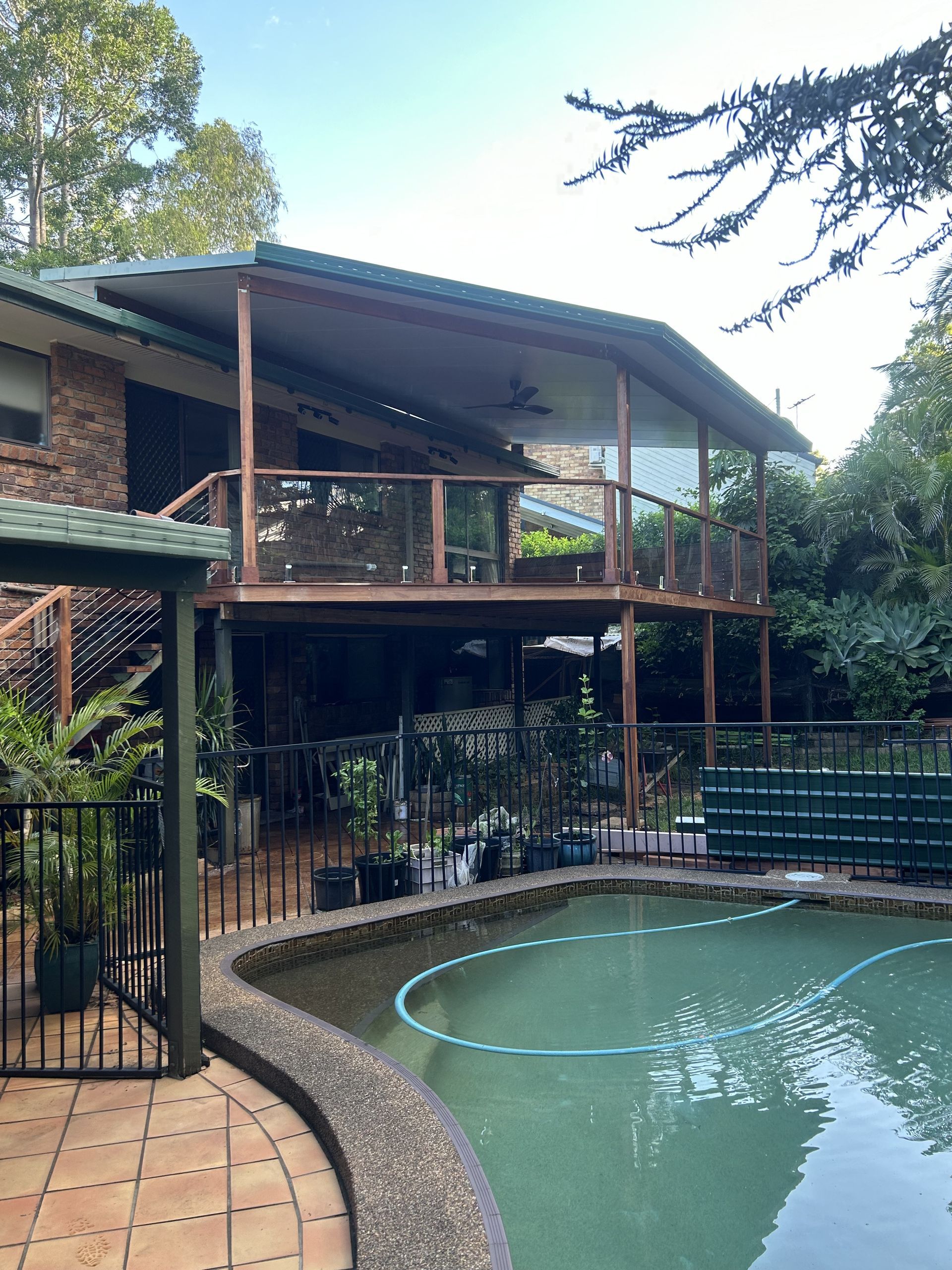 Backyard Pool Beside a Two-story House With Covered Deck — Jordan Building & Construction Pty Ltd in Ascot, QLD