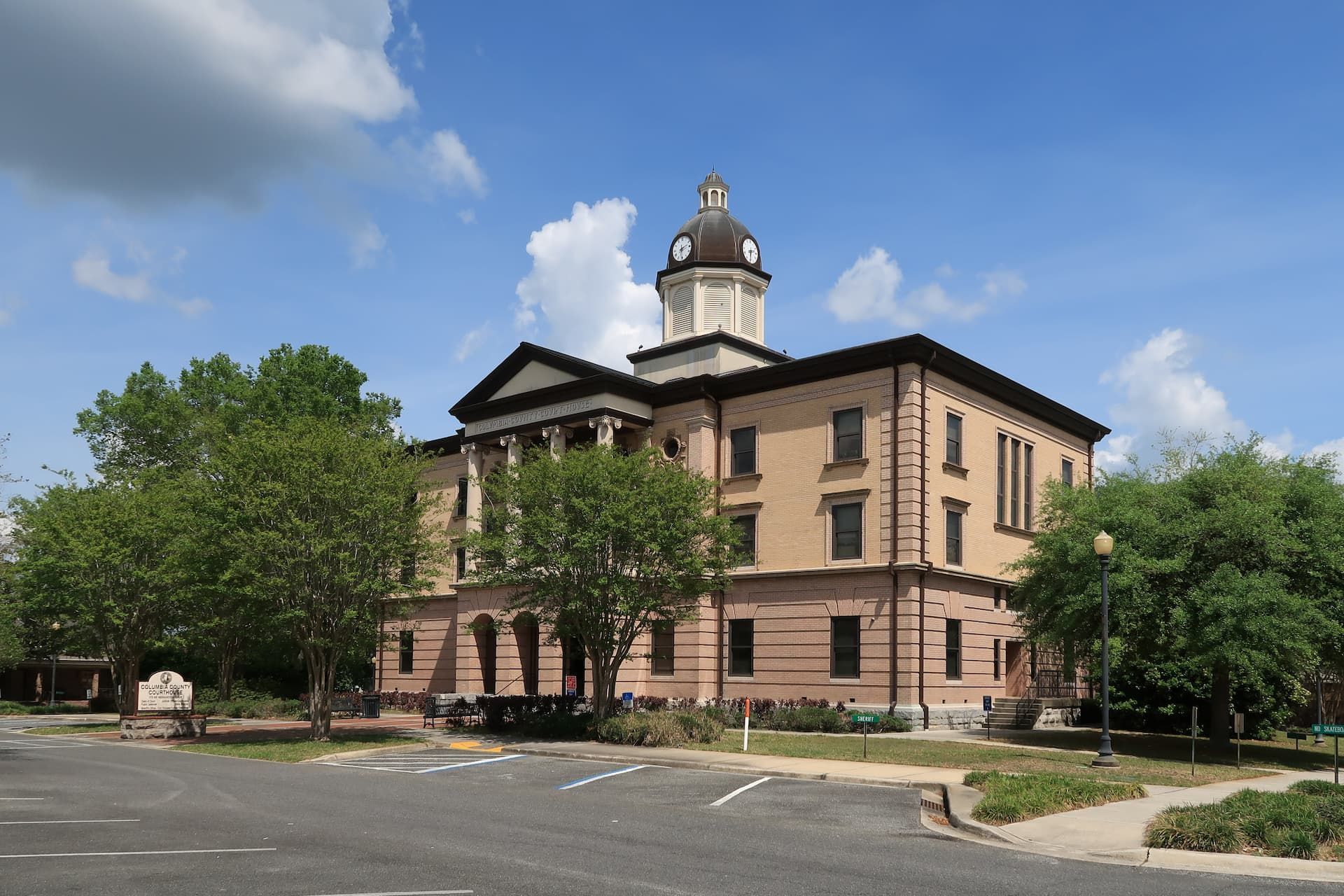 A large white building with a brown roof and a lot of windows.