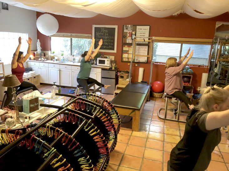 A group of people are doing Pilates  in a room