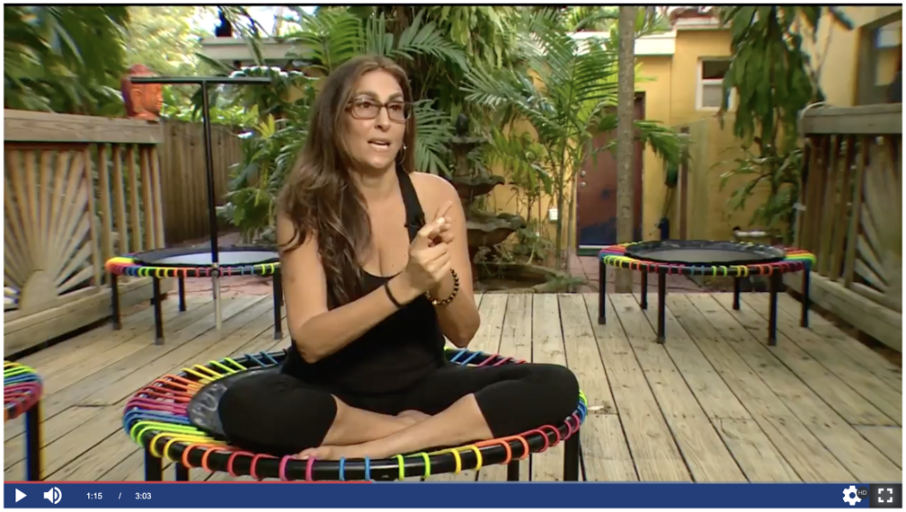 a woman is sitting on a colorful trampoline on a deck .