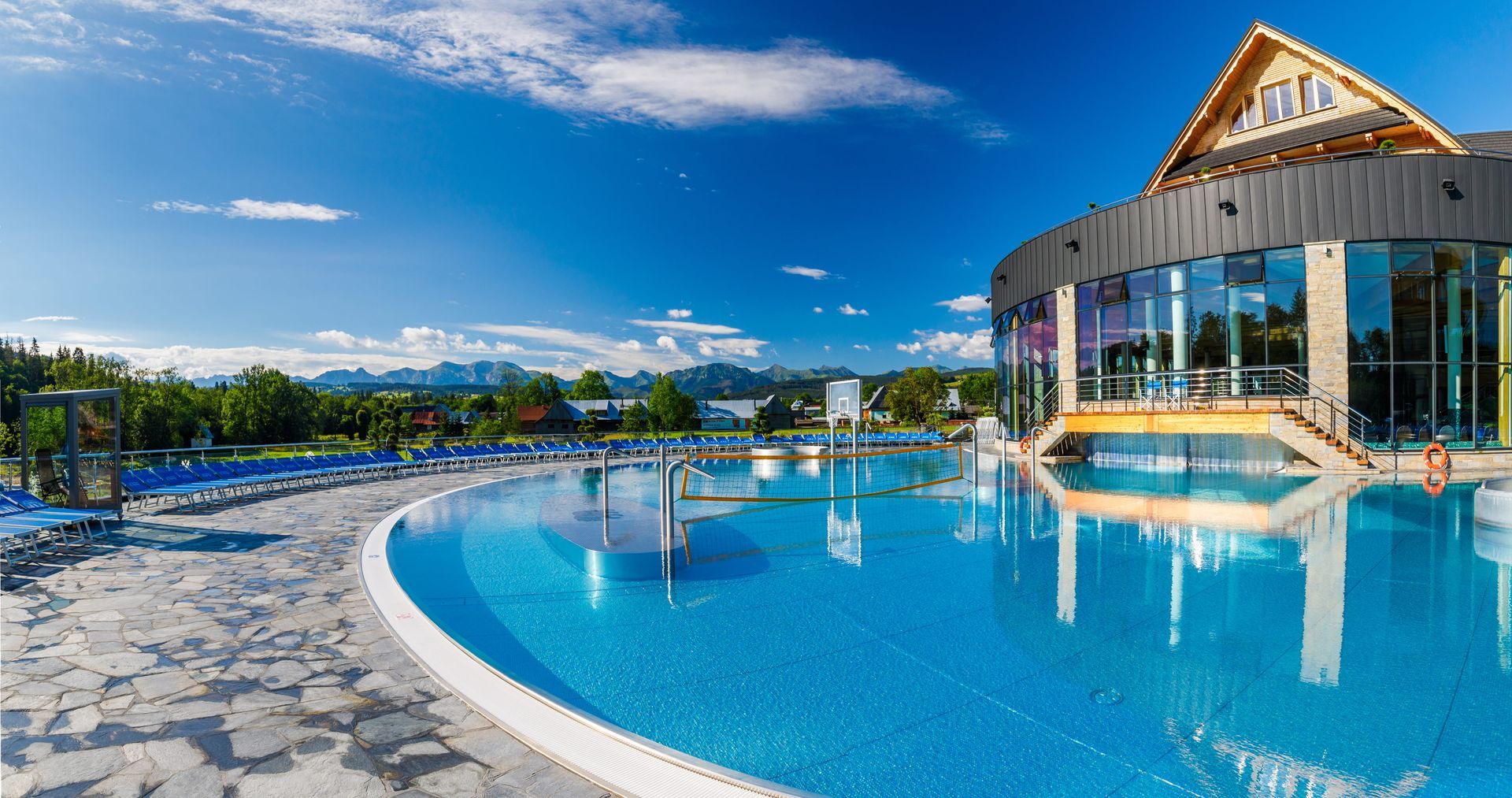 Outdoor pool at Chochołowskie Termy on a sunny summer day with the Tatra Mountains on the horizon