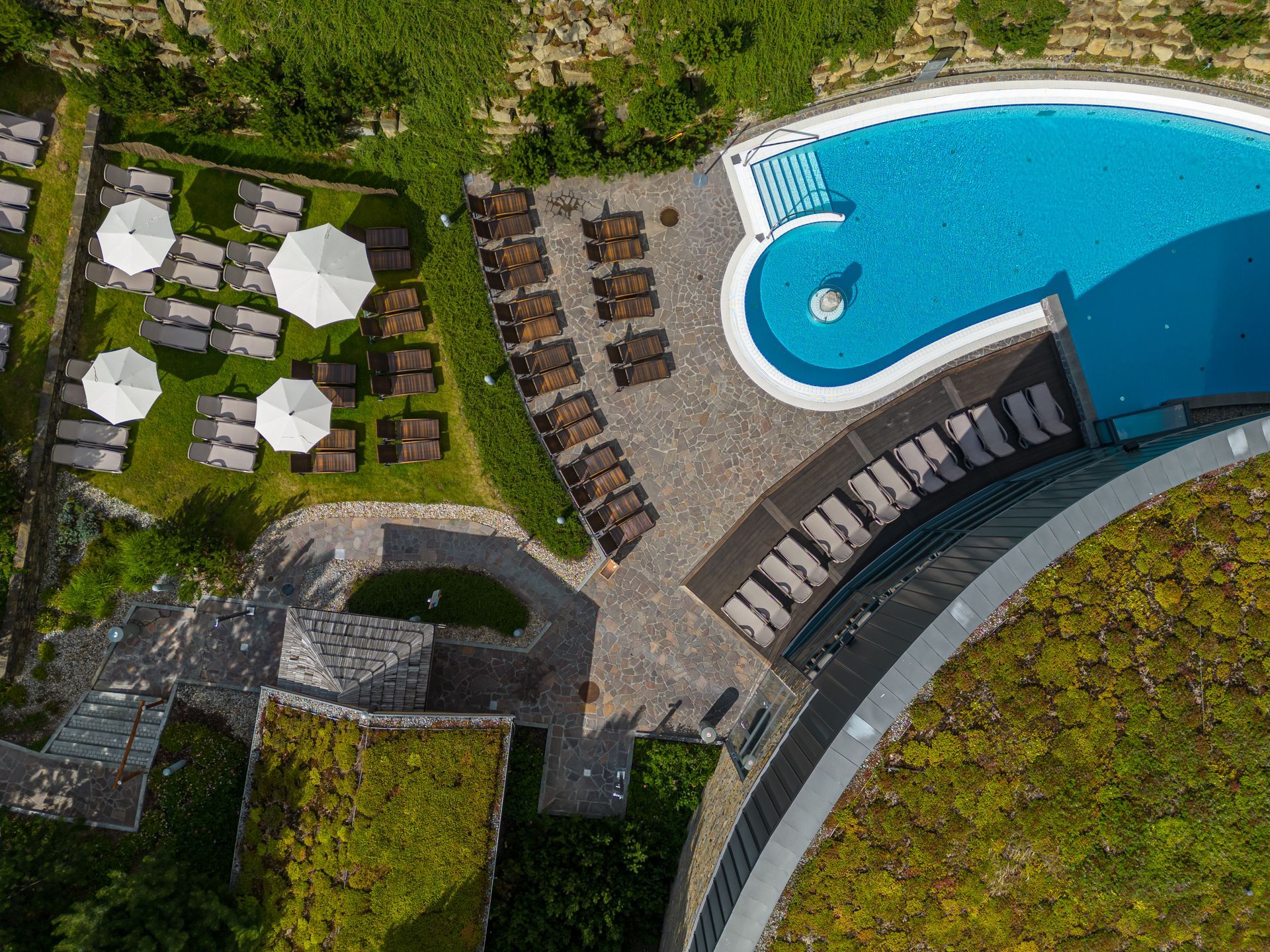 Top-down view of an outdoor pool and sun loungers at Bania Thermal Baths