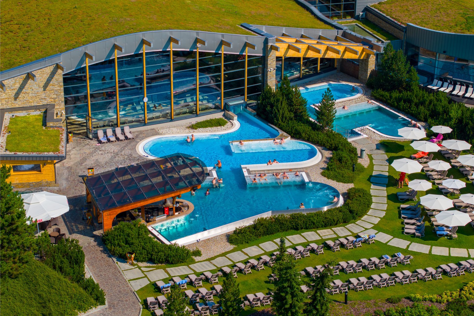 Outdoor thermal pools and sunbed area at Terma Bania in summer