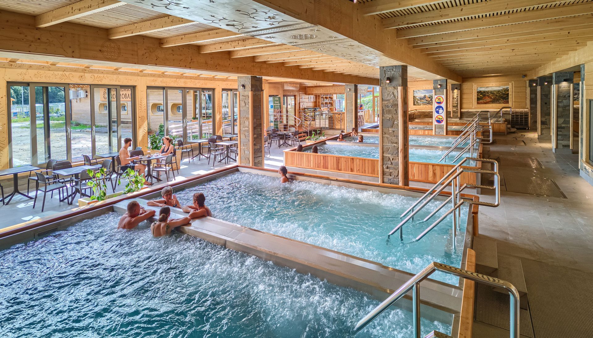 Indoor thermal pools with hydromassage benches and a relaxation area at Chochołowskie Termy