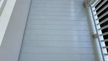 White horizontal siding on a house exterior with a white window shutter on the right.