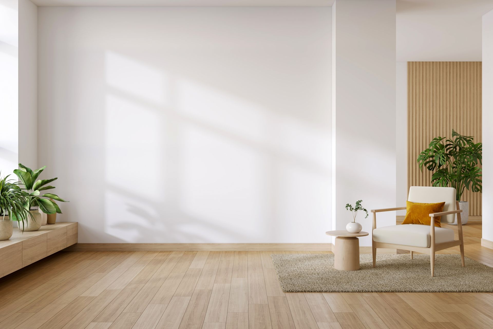 Minimalist living room with a beige sofa, white chair, potted plants, and sunlight on a blank wall