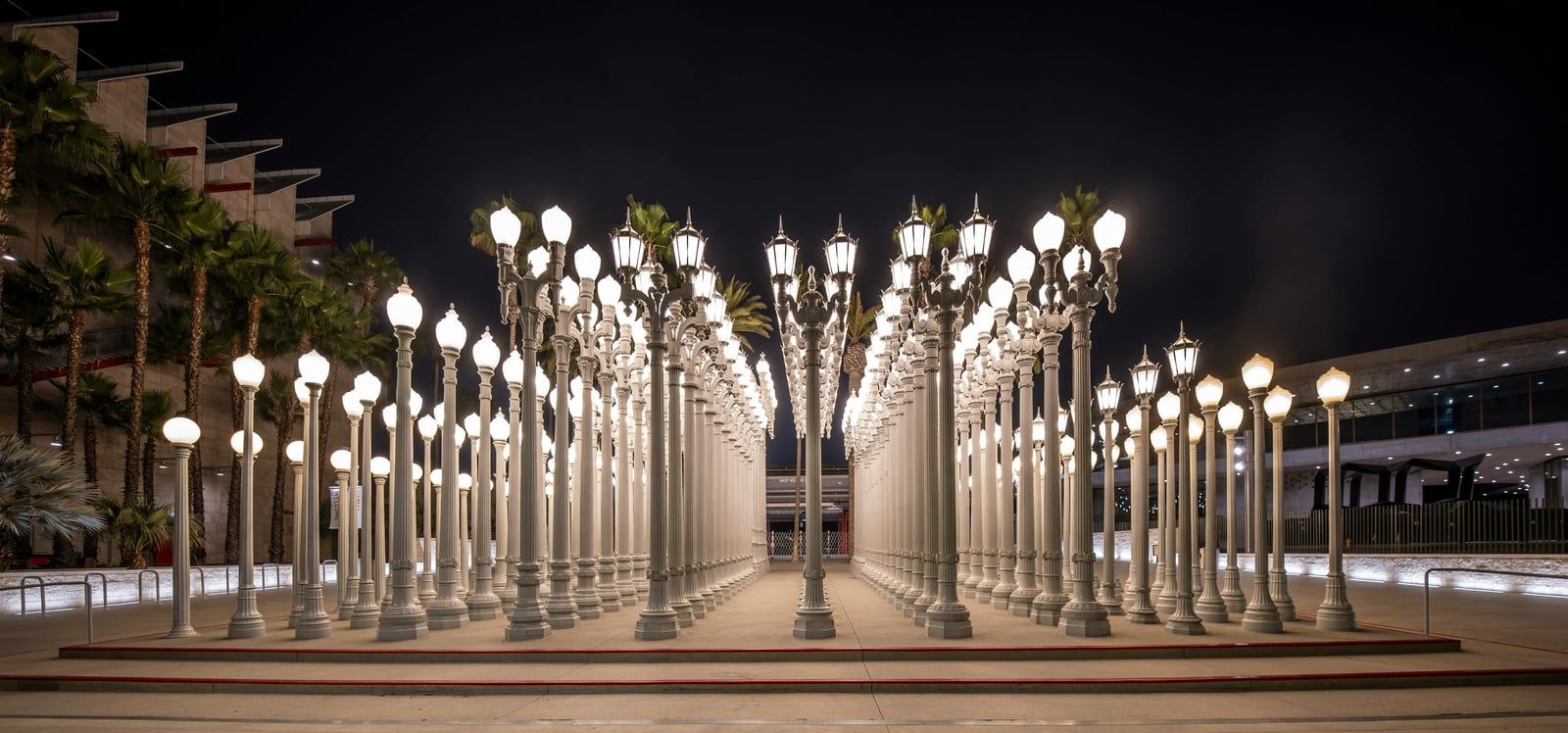 Rows of glowing streetlights in a symmetrical outdoor plaza at night