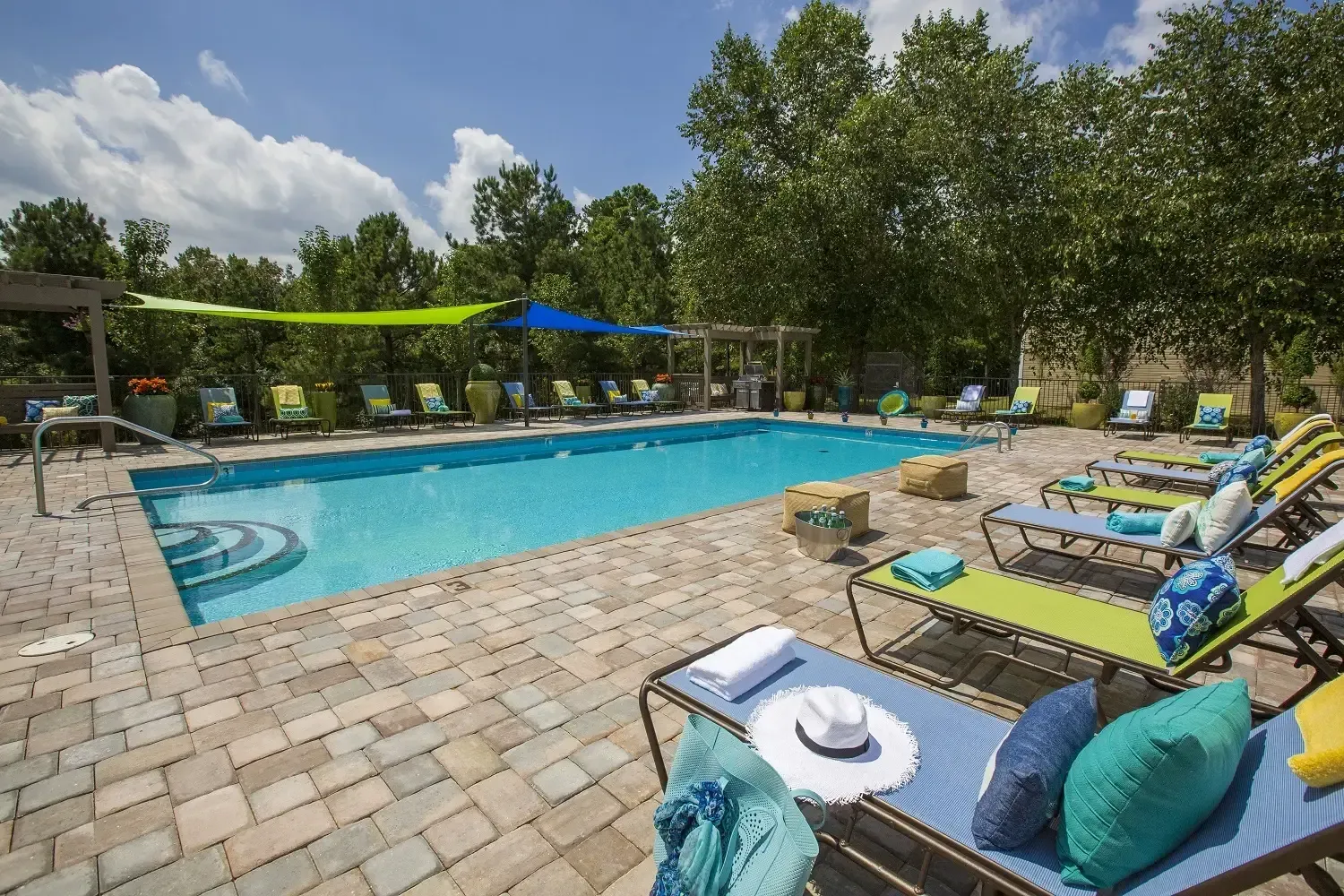 Photo of the community pool, with poolside chairs on three sides
