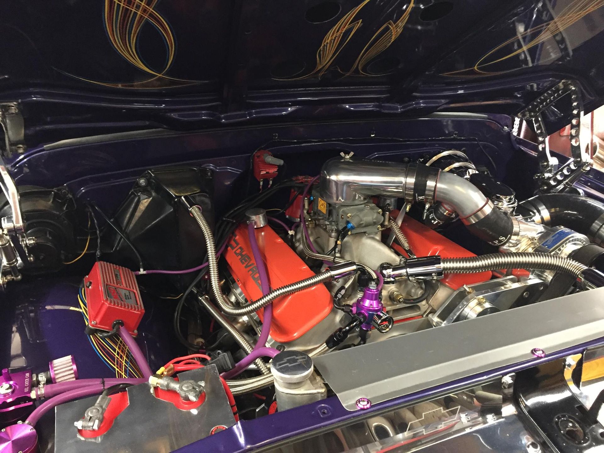 A close up of a car engine with the hood open