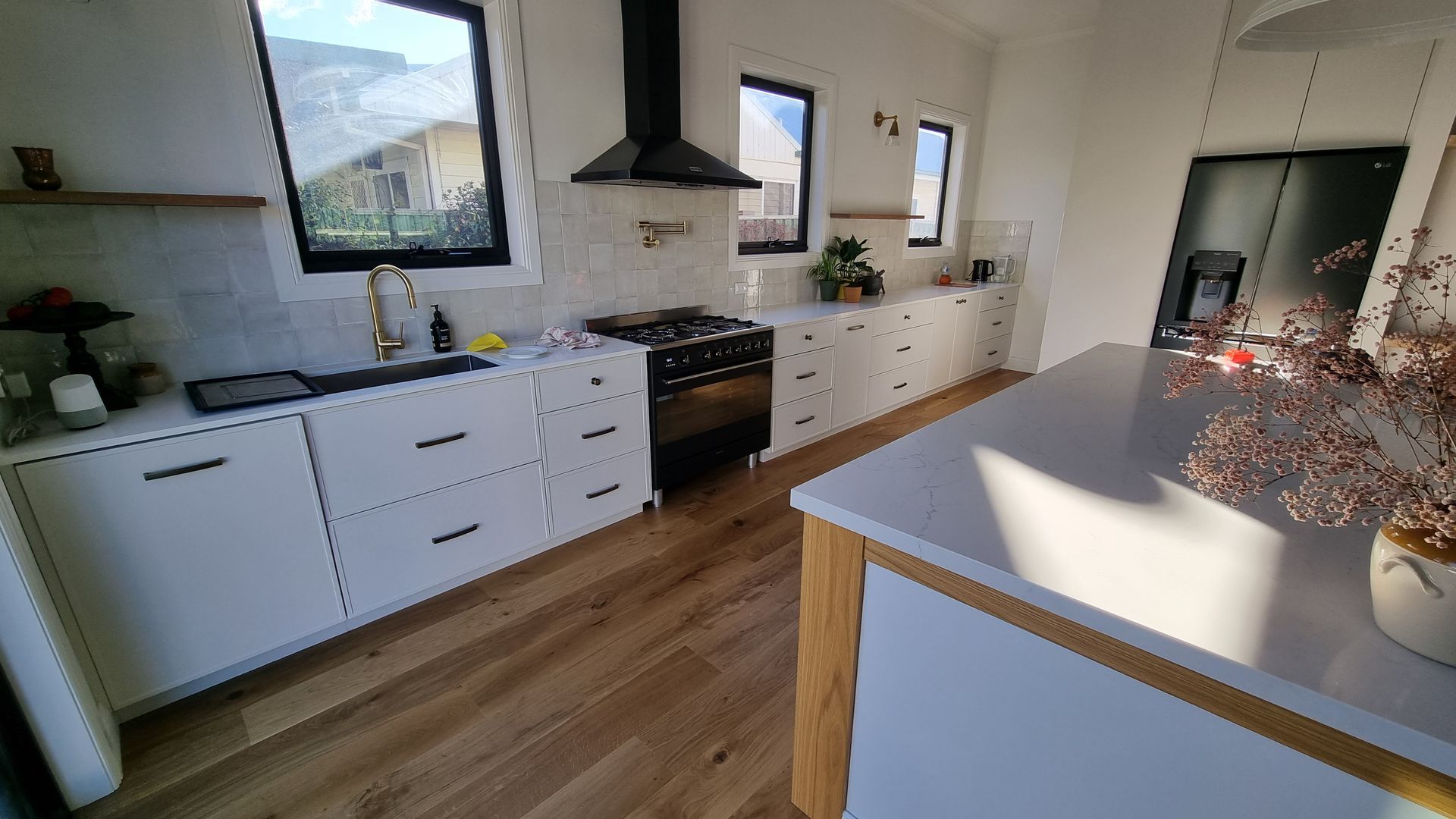 Bright modern kitchen with white cabinets, wood floors  — Crowfoot Constructions in Dubbo, NSW