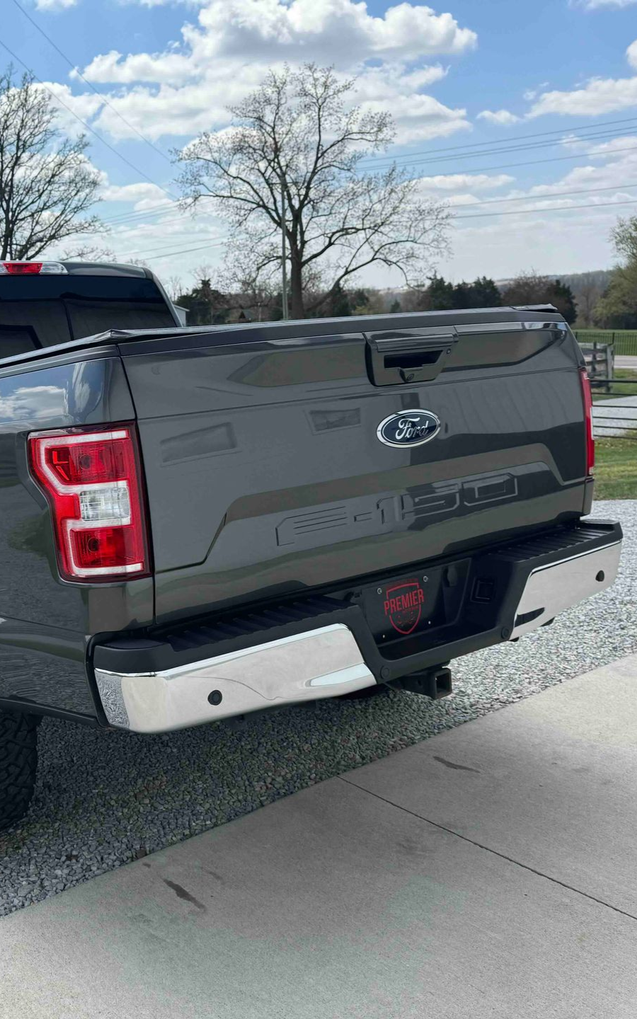 Dark gray Ford F-150 truck rear, chrome bumper,
