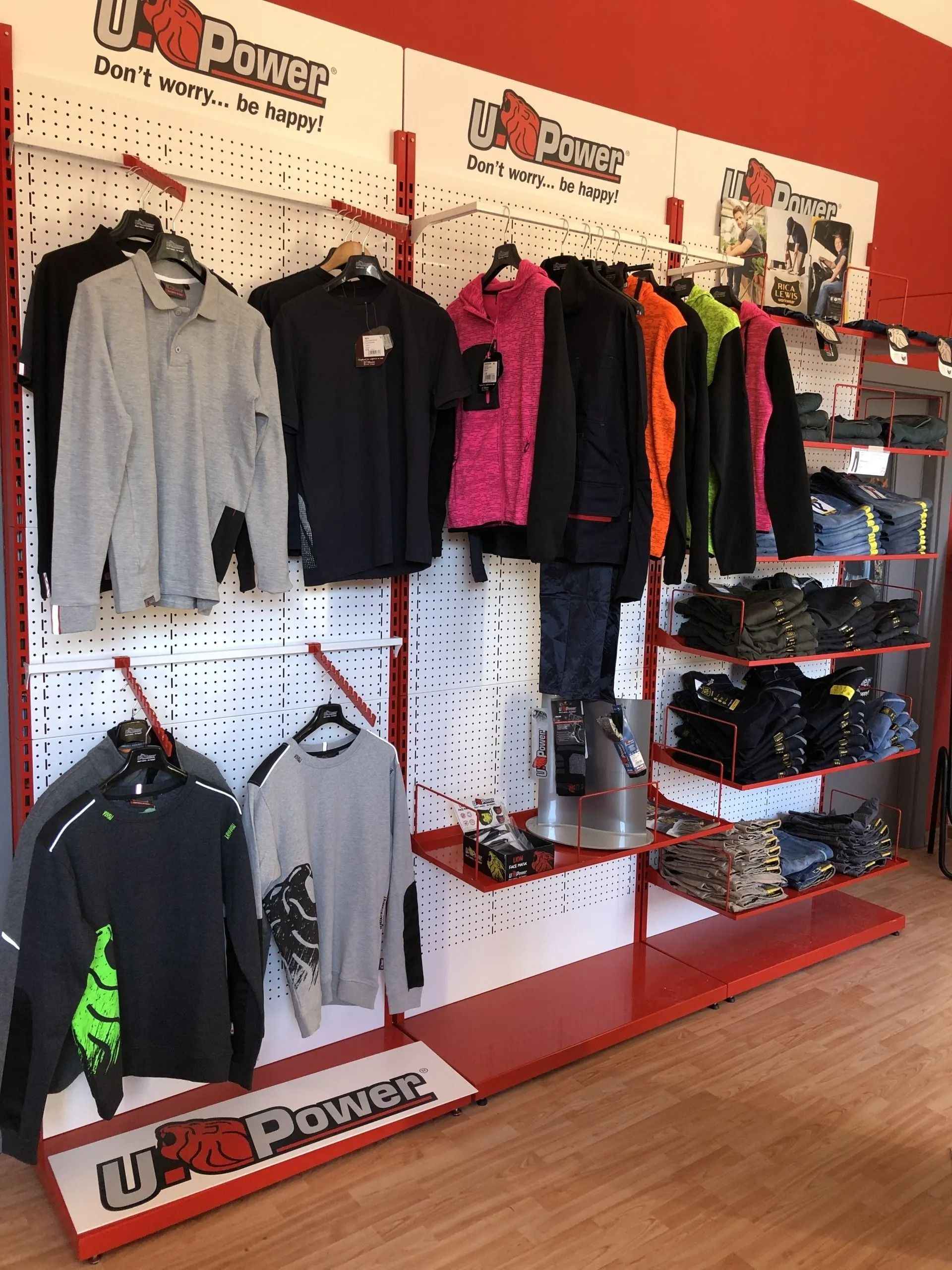 Esposizione di abbigliamento da motociclista con giacche, guanti e caschi su pareti e scaffali in un negozio al dettaglio