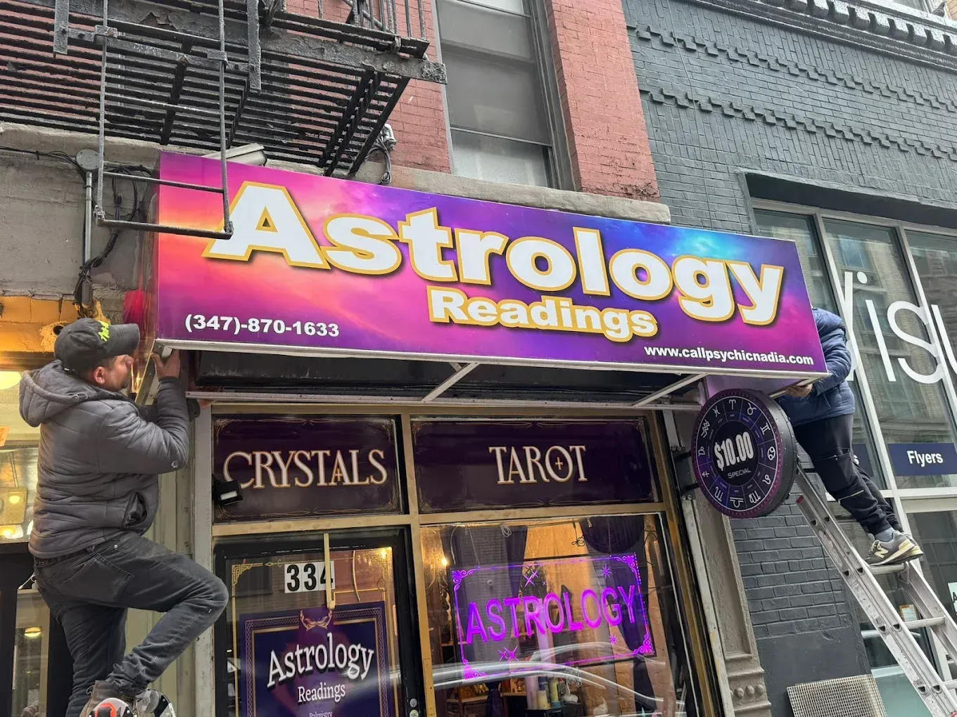 A man on a ladder is working on a garage door.