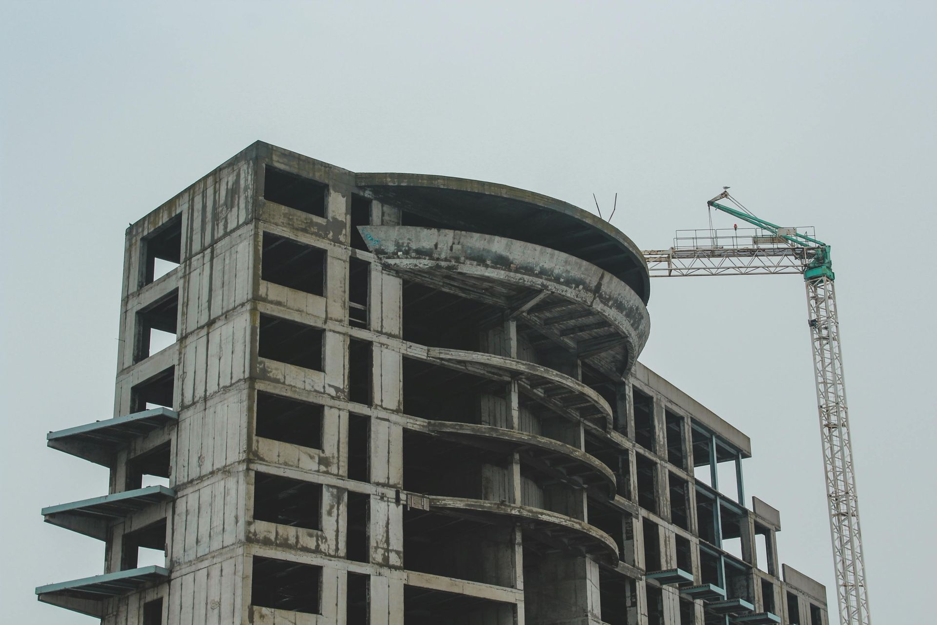A large building under construction with a crane in front of it.