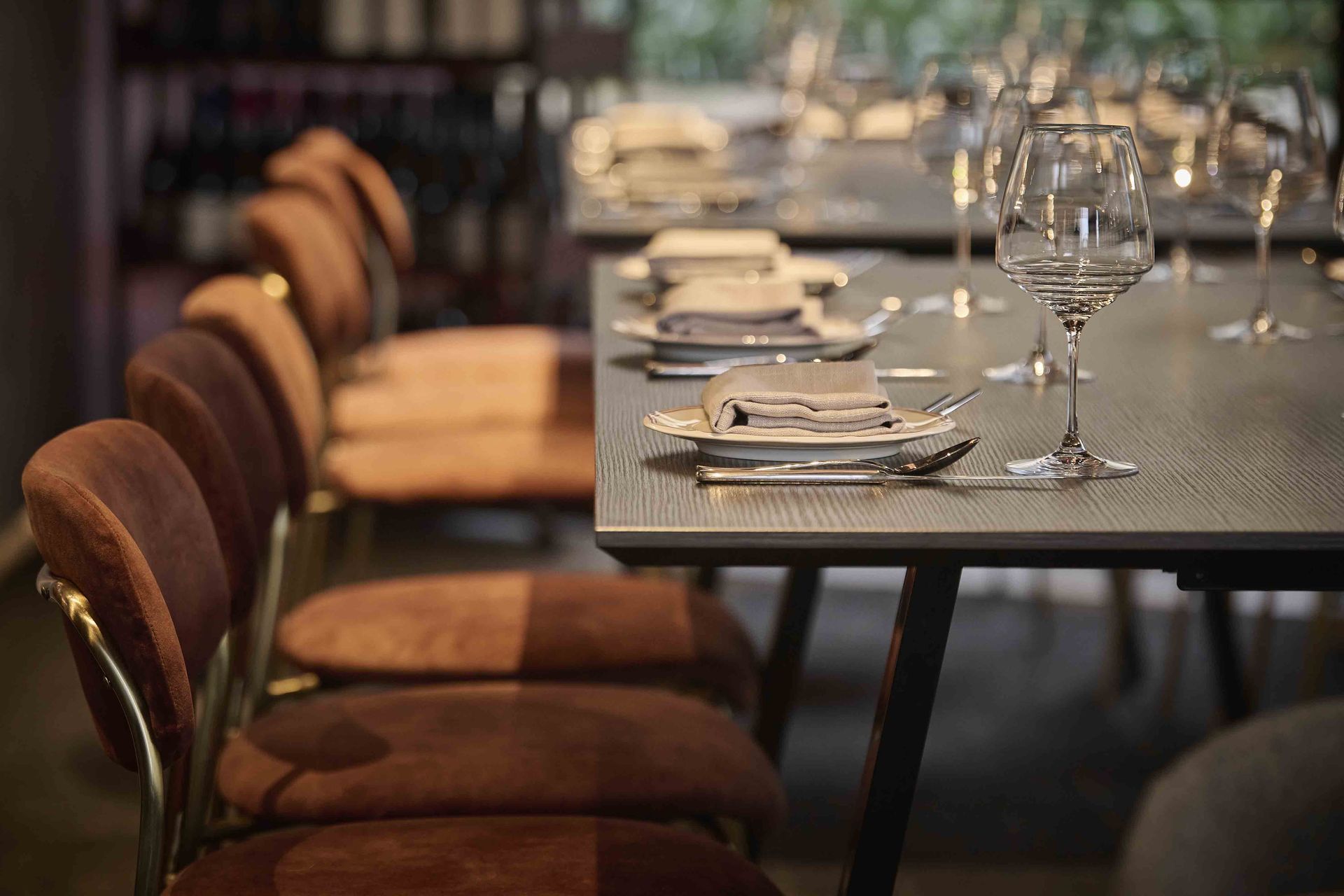 Set dining table with brown chairs in a softly lit restaurant