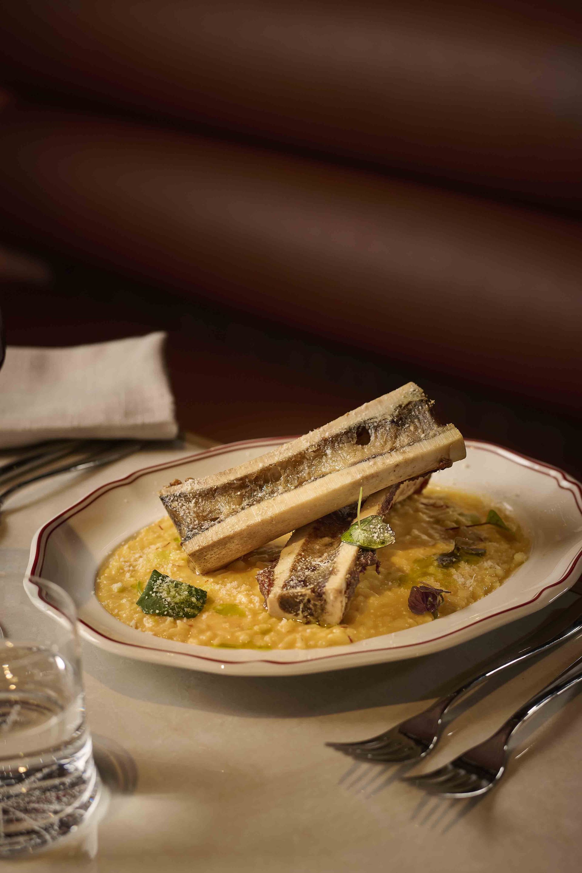 Breaded fish or meat over creamy sauce with herbs on a plate, in a restaurant setting