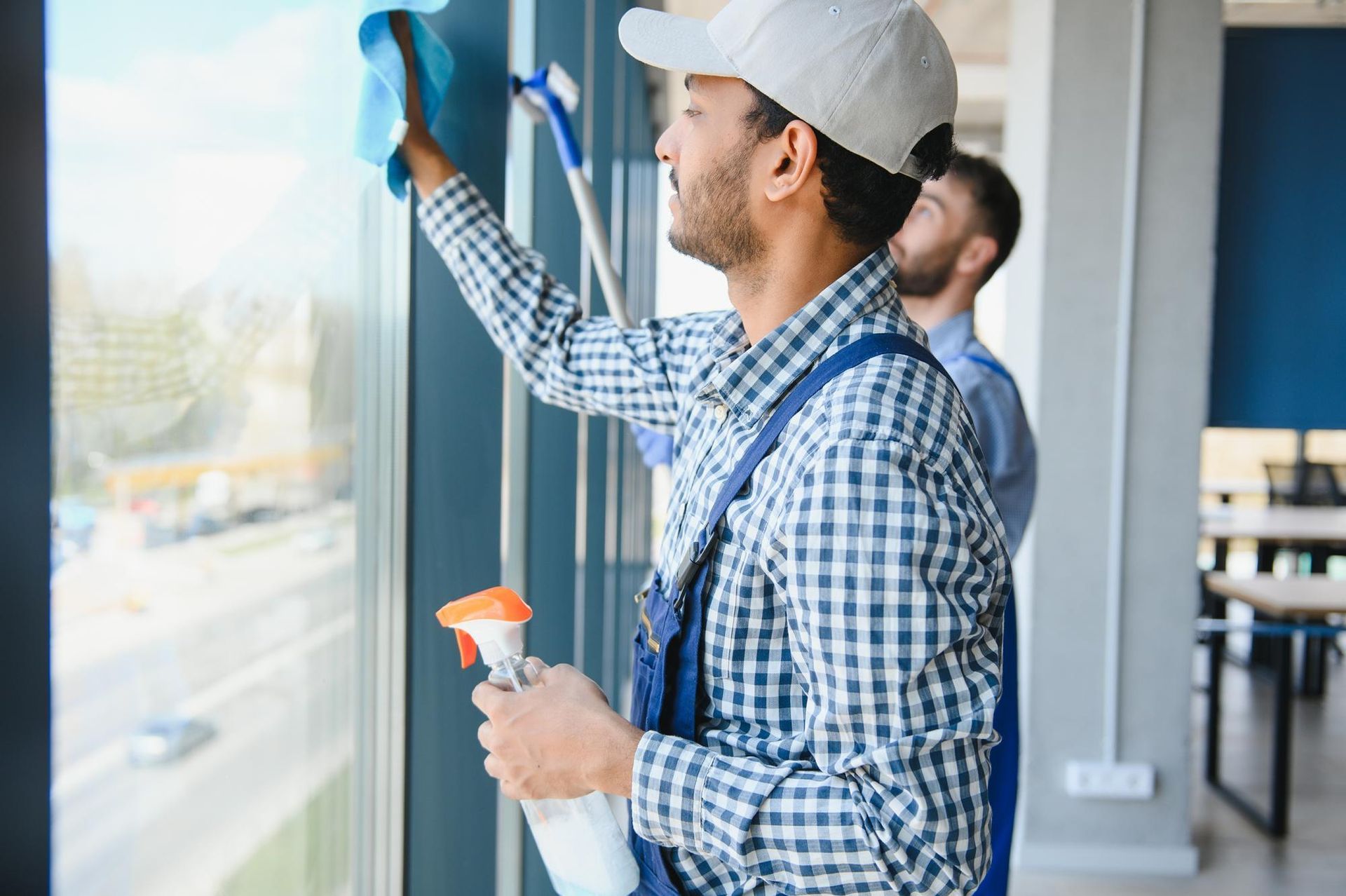 A man is cleaning a window with a spray bottle.