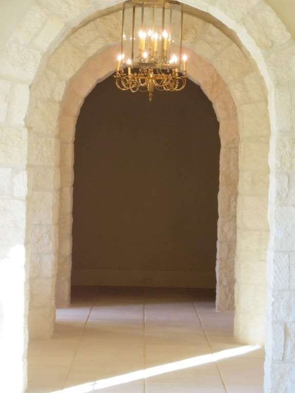 A stone archway with a chandelier hanging from the ceiling
