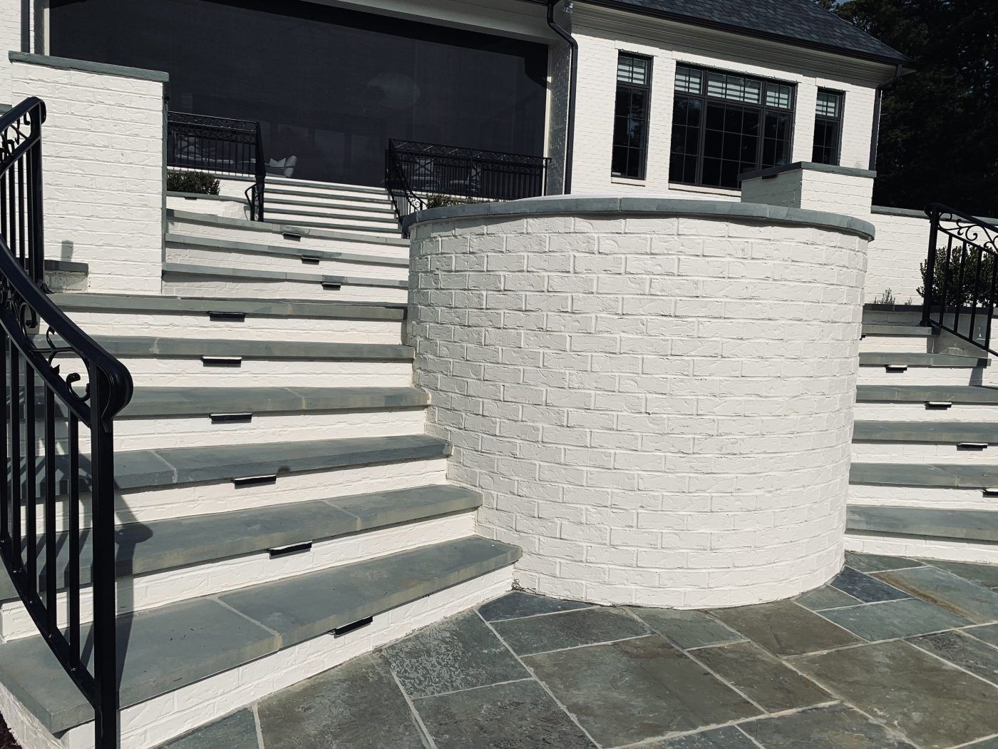 A set of stairs leading up to a house with a black railing