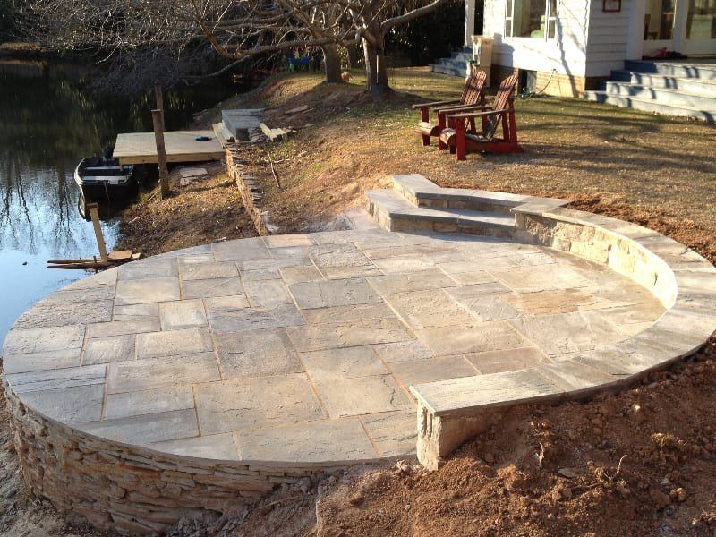 A circular patio is being built next to a body of water
