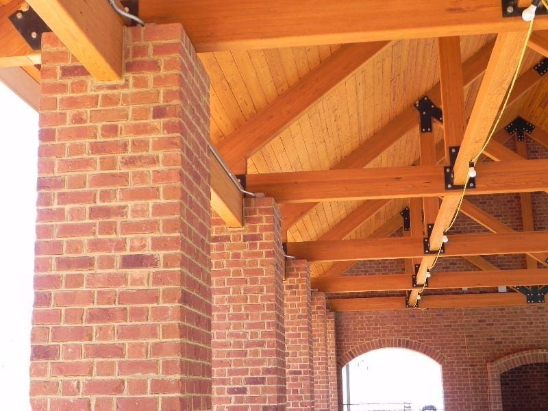 A brick building with a wooden roof and beams