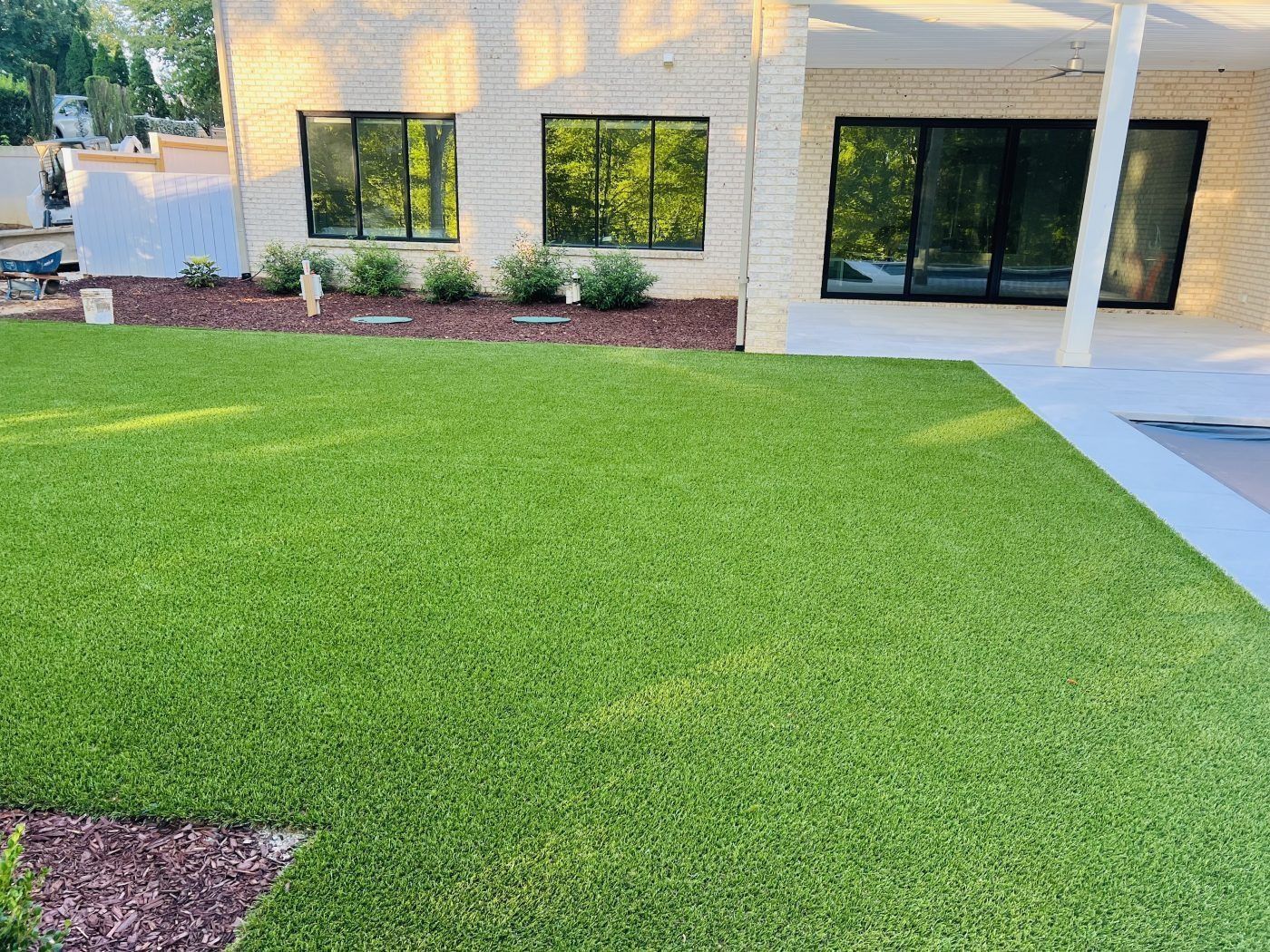 A large lawn in front of a house with a lot of windows
