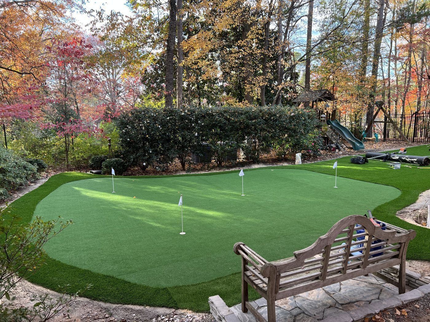 There is a bench in the middle of the putting green