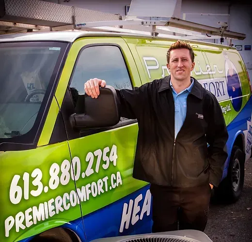 a man standing in front of a green and blue van that says premier comfort